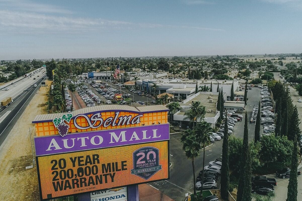 Aerial view of Selma Auto Mall billboard, highway, and car dealerships/parking lots.
